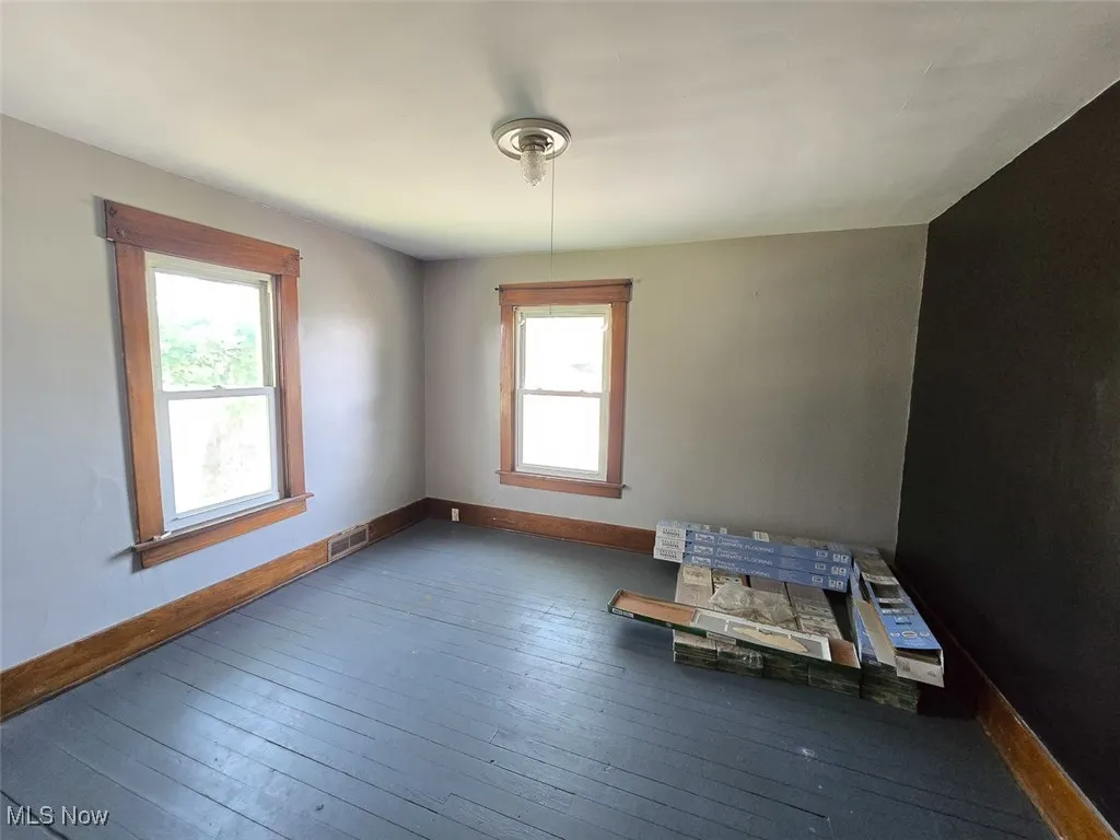 Empty room featuring baseboards and hardwood / wood-style flooring