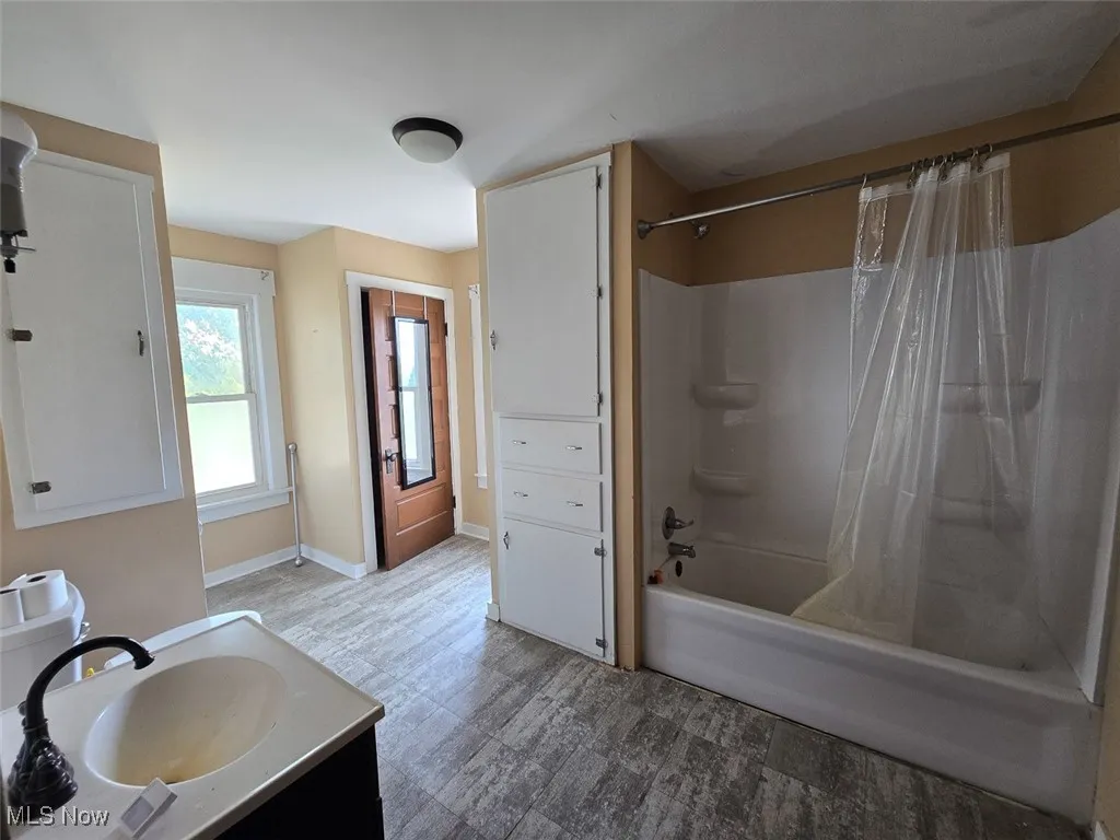 Full bathroom featuring shower / bath combo and vanity