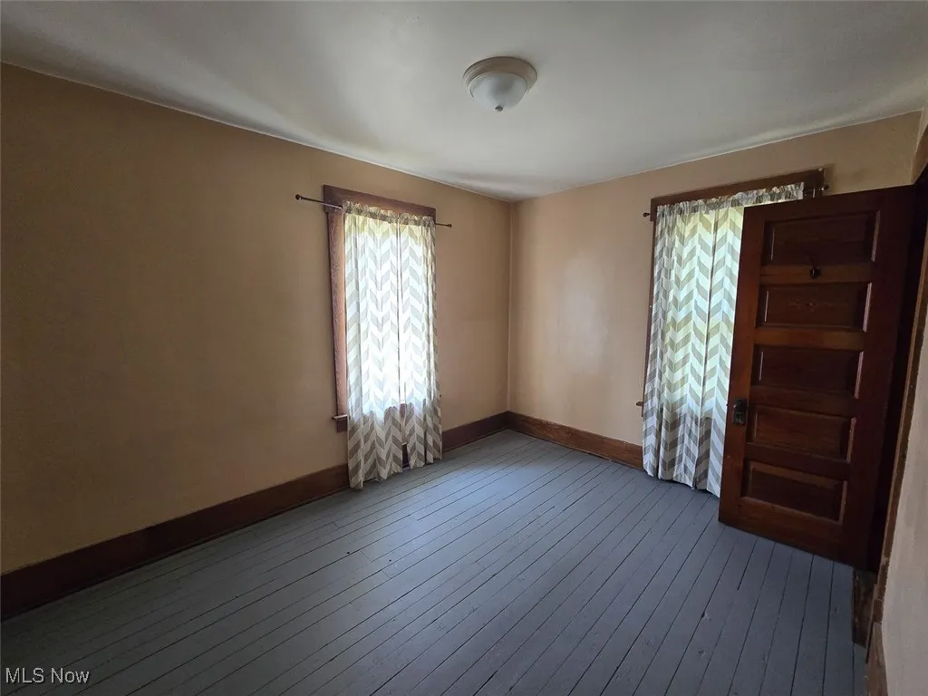 Empty room featuring baseboards and hardwood / wood-style floors