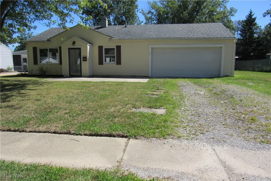 Single story home featuring driveway, a garage, and a shingled roof
