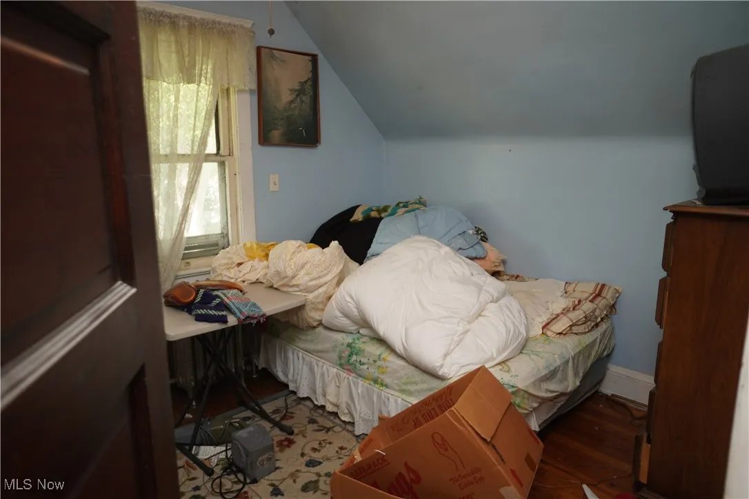 Bedroom with vaulted ceiling and wood finished floors