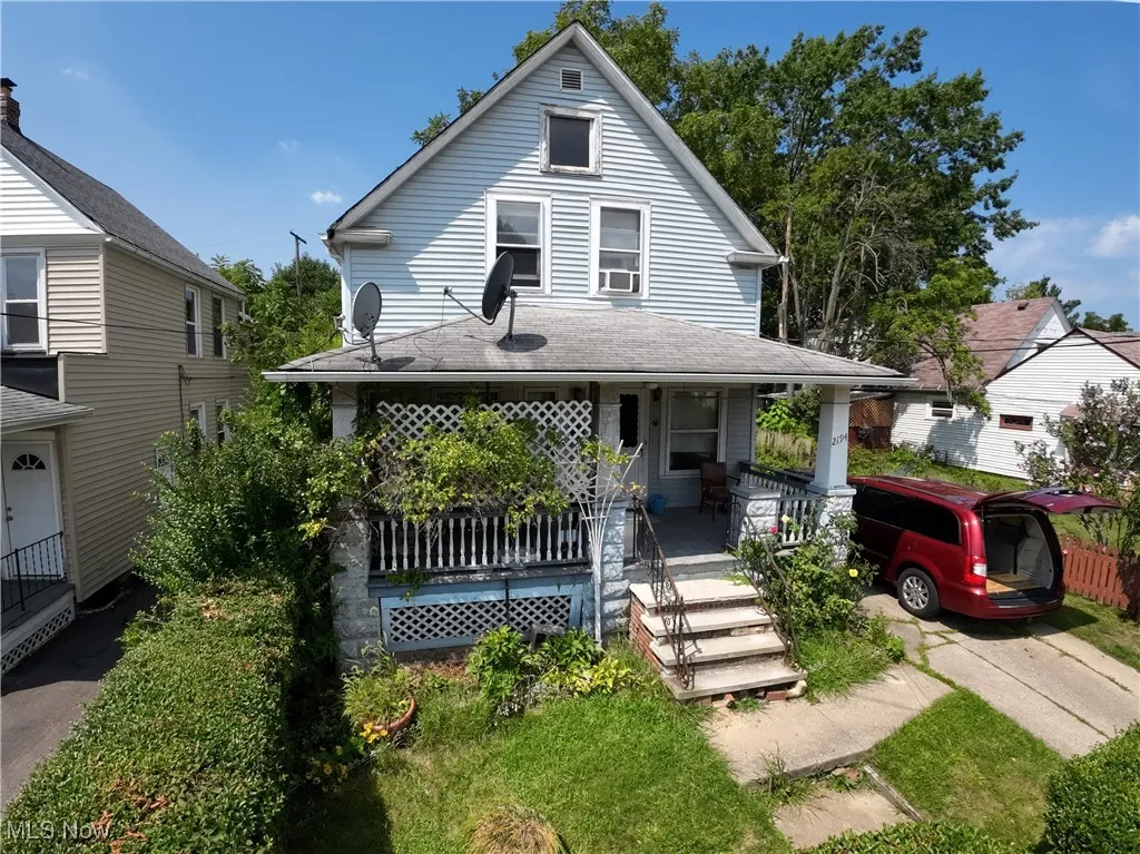 View of front of property with covered porch and roof with shingles
