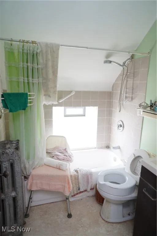Bathroom with shower / tub combo with curtain, vanity, and radiator heating unit