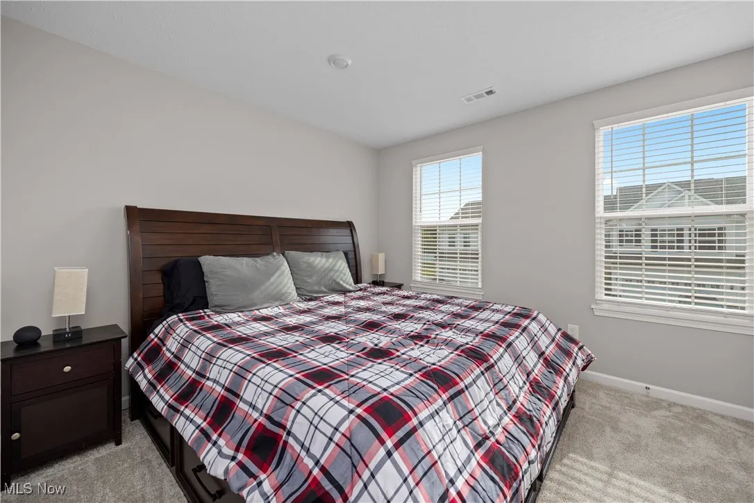 Bedroom with light carpet and baseboards