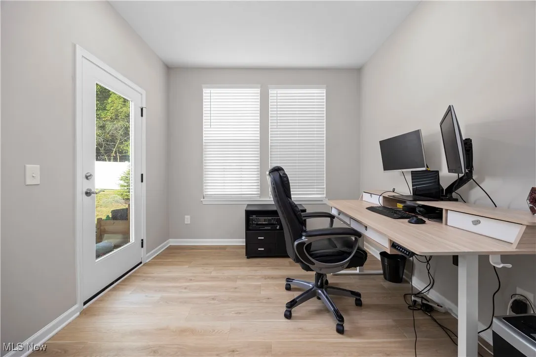 Home office with light wood-type flooring and baseboards