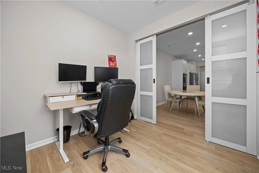 Home office featuring light wood finished floors and recessed lighting
