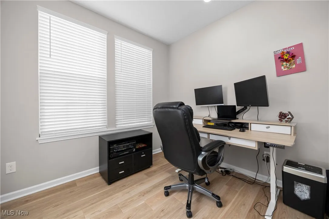 Office area with light wood-style floors and baseboards