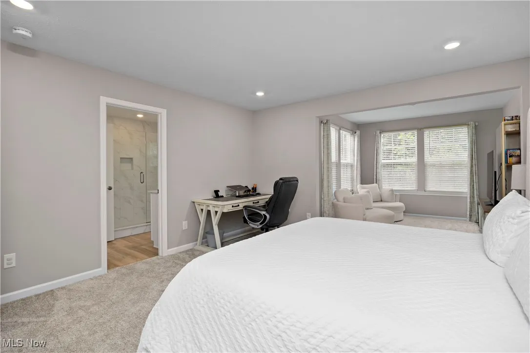 Bedroom featuring light carpet, an office area, recessed lighting, and ensuite bath