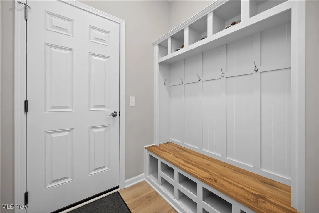 Mudroom with light wood-style floors and baseboards