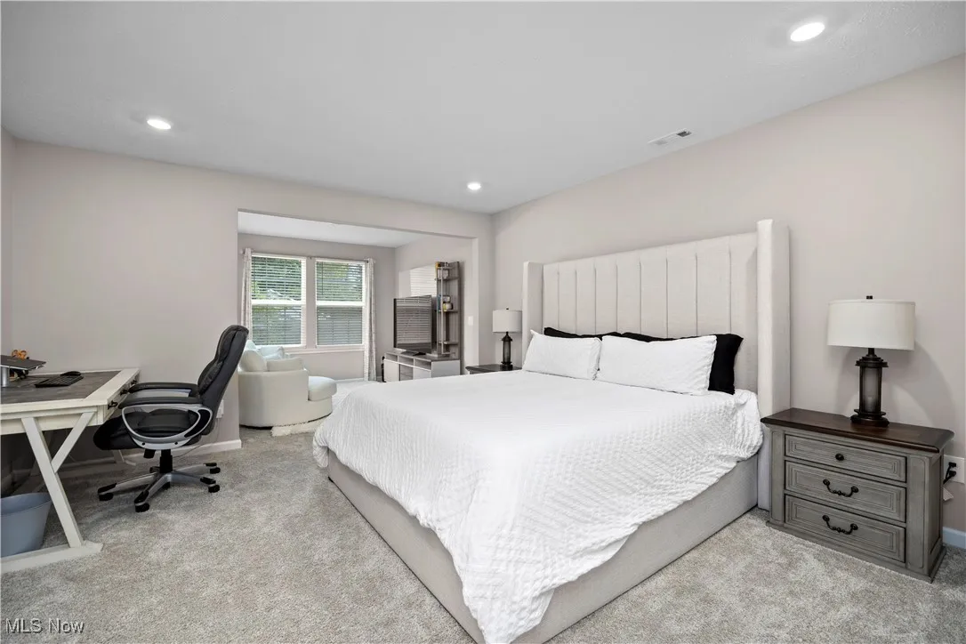 Bedroom featuring light carpet, an office area, and recessed lighting