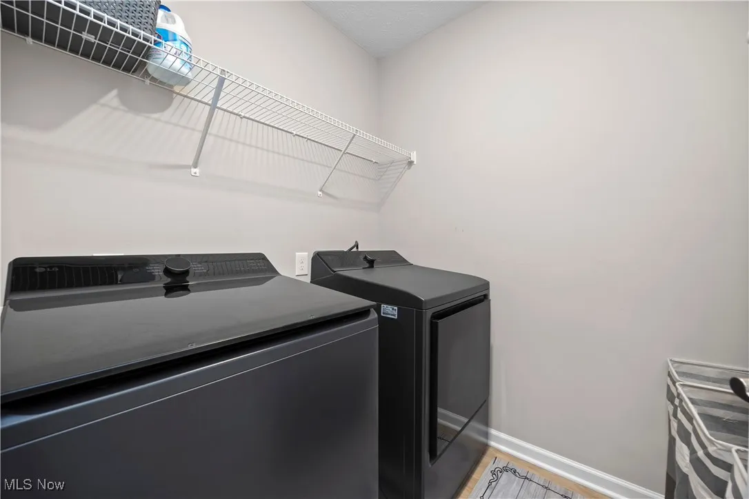 Laundry area with washing machine and dryer and wood finished floors