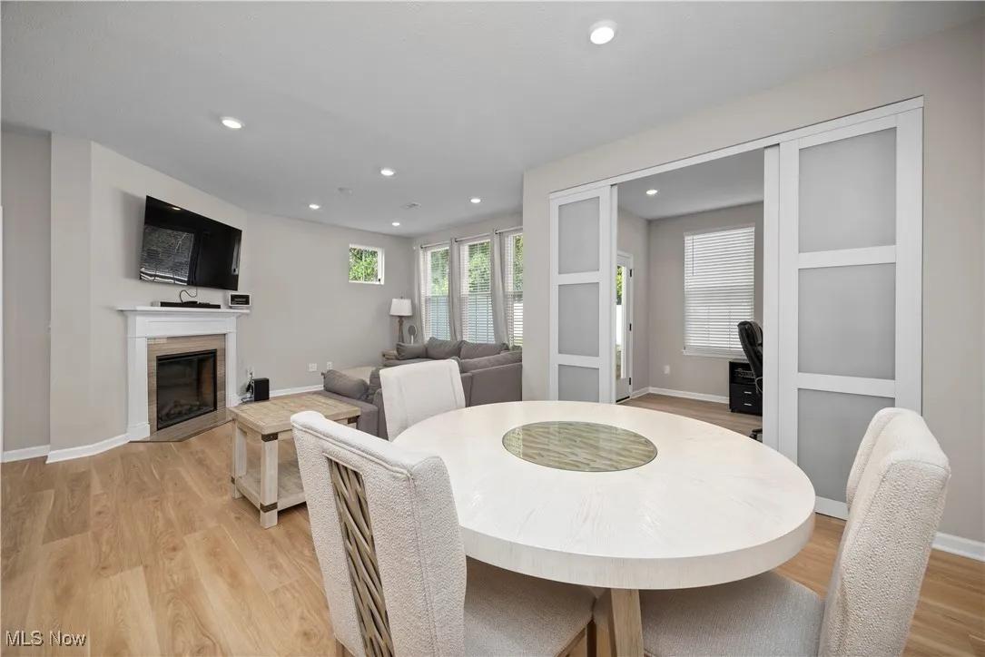 Dining area featuring recessed lighting, light wood finished floors, and a glass covered fireplace