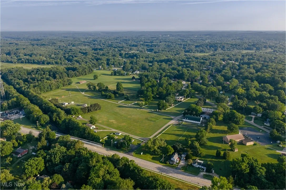 Aerial view of property and surrounding area featuring a heavily wooded area