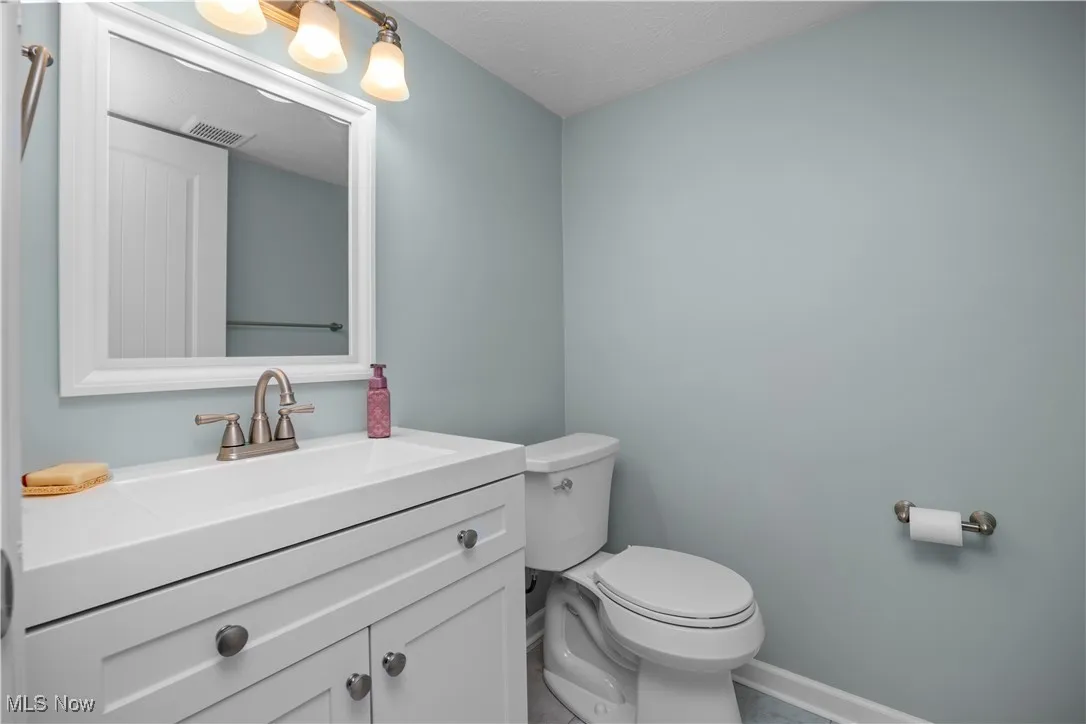 Half bath featuring vanity and a textured ceiling