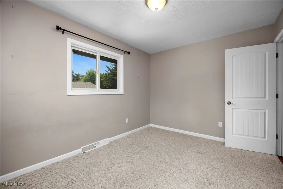 Unfurnished room featuring carpet flooring and a textured ceiling