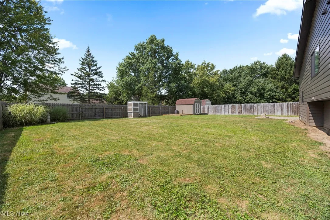Fenced backyard featuring a shed