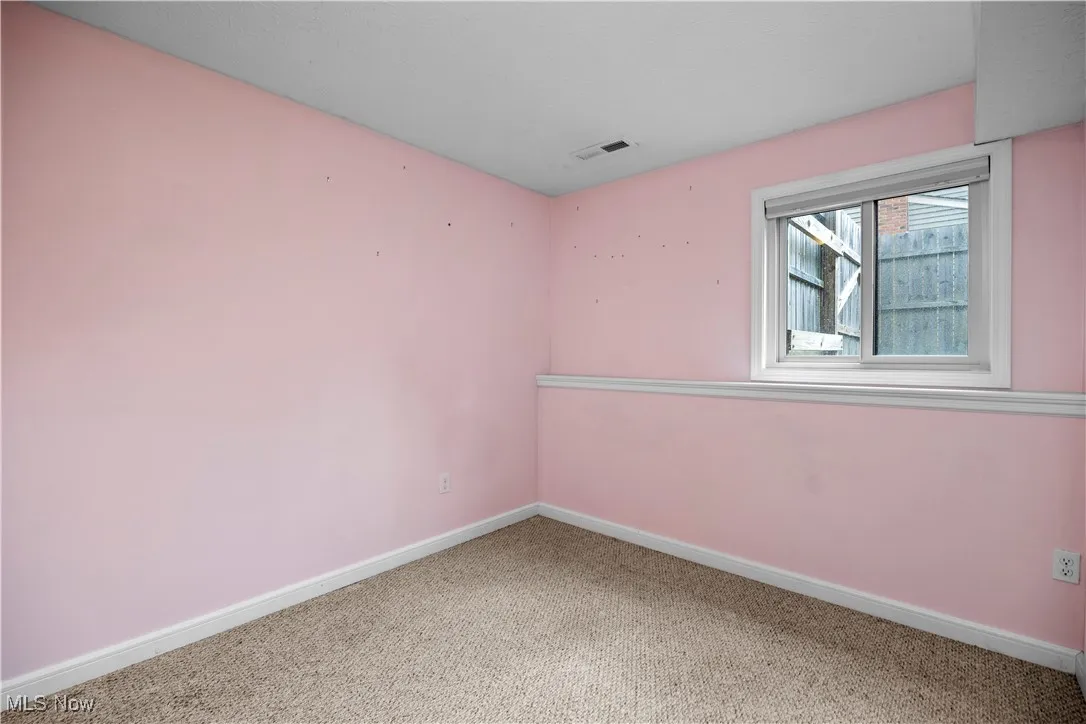 Spare room featuring carpet flooring and baseboards