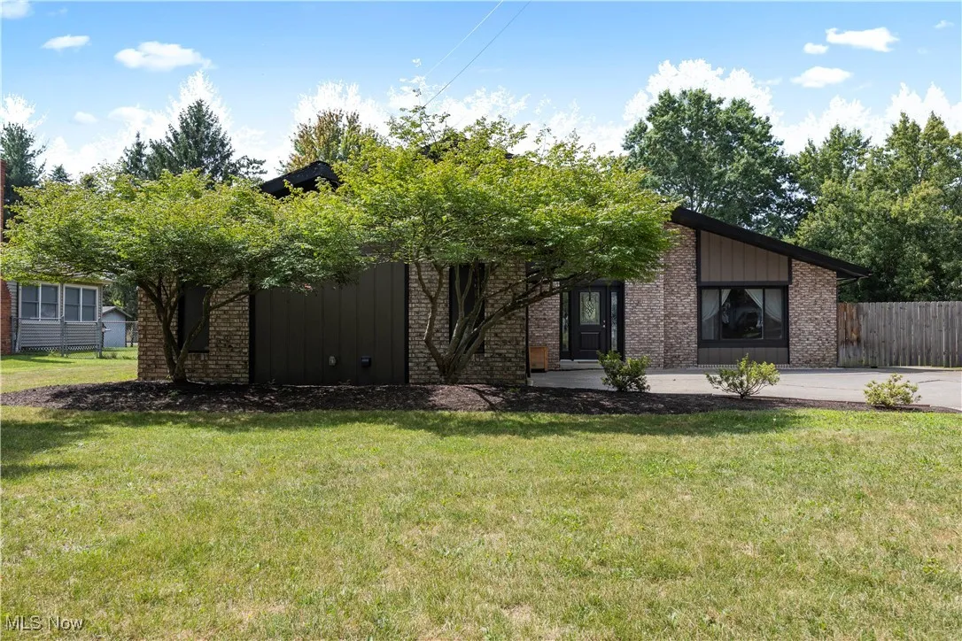 Mid-century modern home featuring brick siding