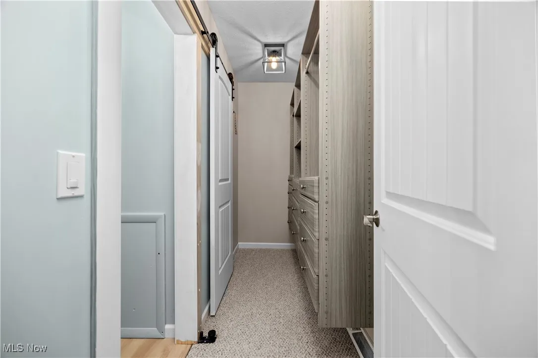 Hall featuring a barn door and baseboards