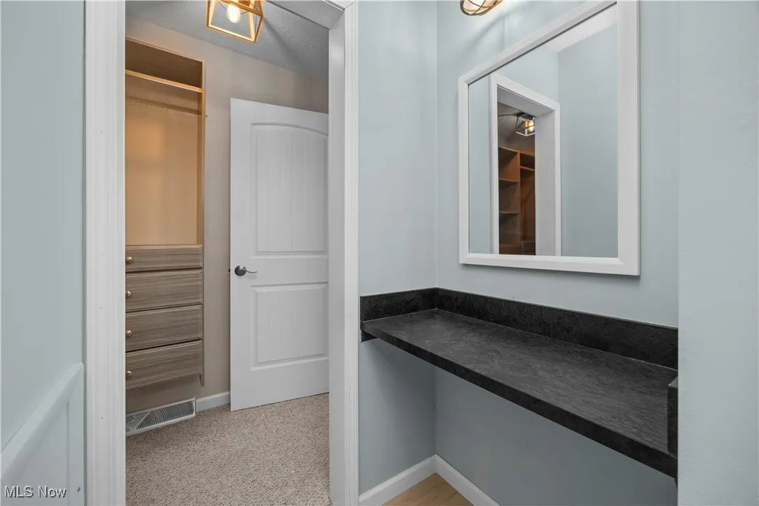 Hall featuring baseboards and light carpet