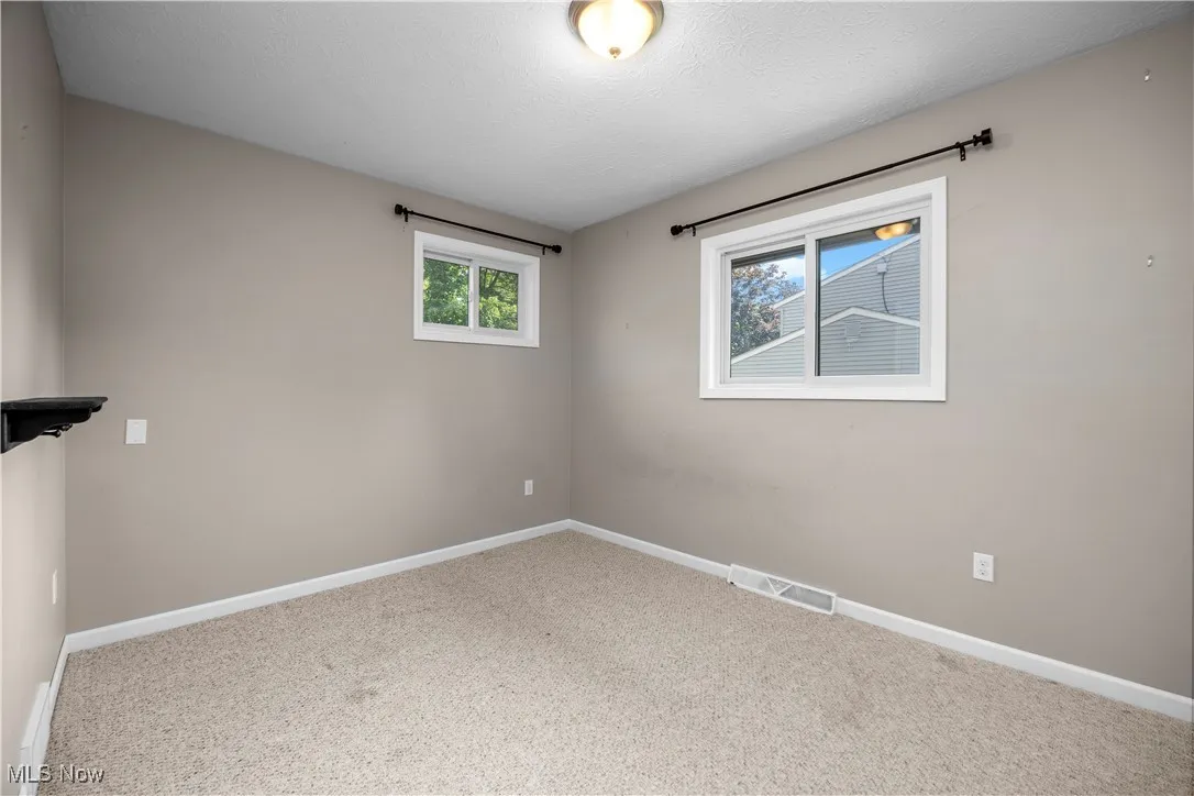 Carpeted spare room with baseboards and a textured ceiling