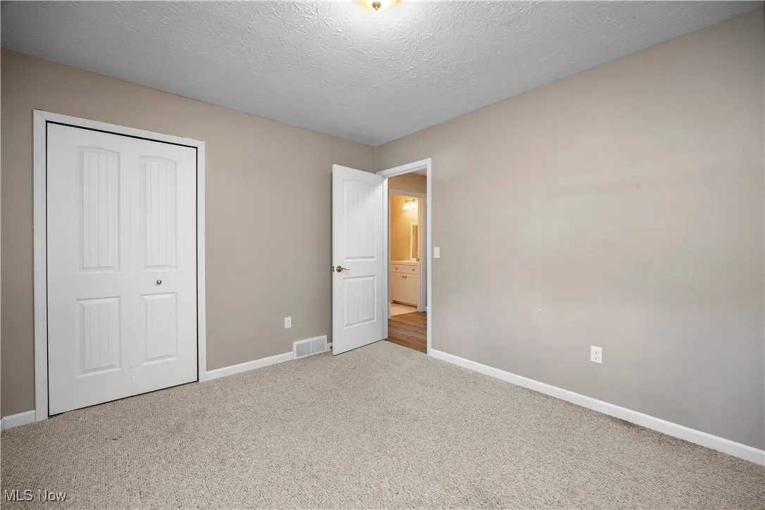 Unfurnished bedroom with a textured ceiling, carpet floors, and a​​‌​​​​‌​​‌‌​‌‌​​​‌‌​‌​‌​‌​​​‌​​ closet