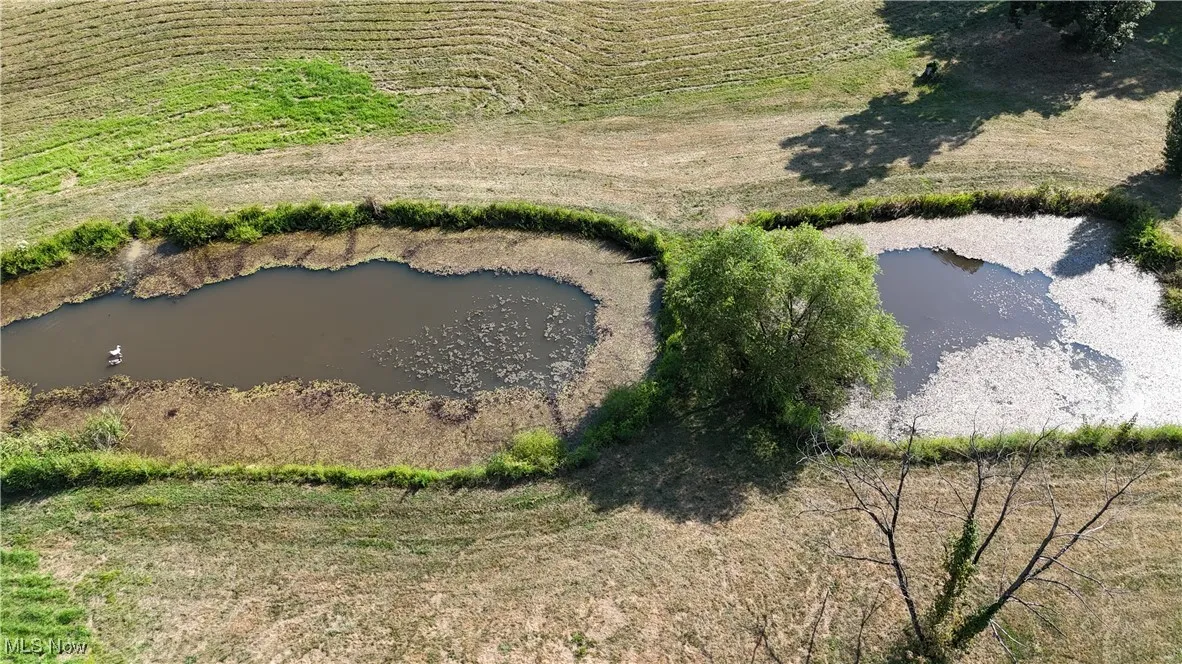 Overview of rural landscape with a nearby body of water and large plots for crops