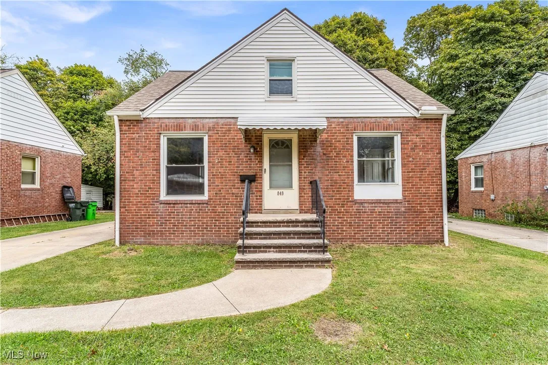 Bungalow-style home featuring a front lawn, brick siding, and a shingled roof