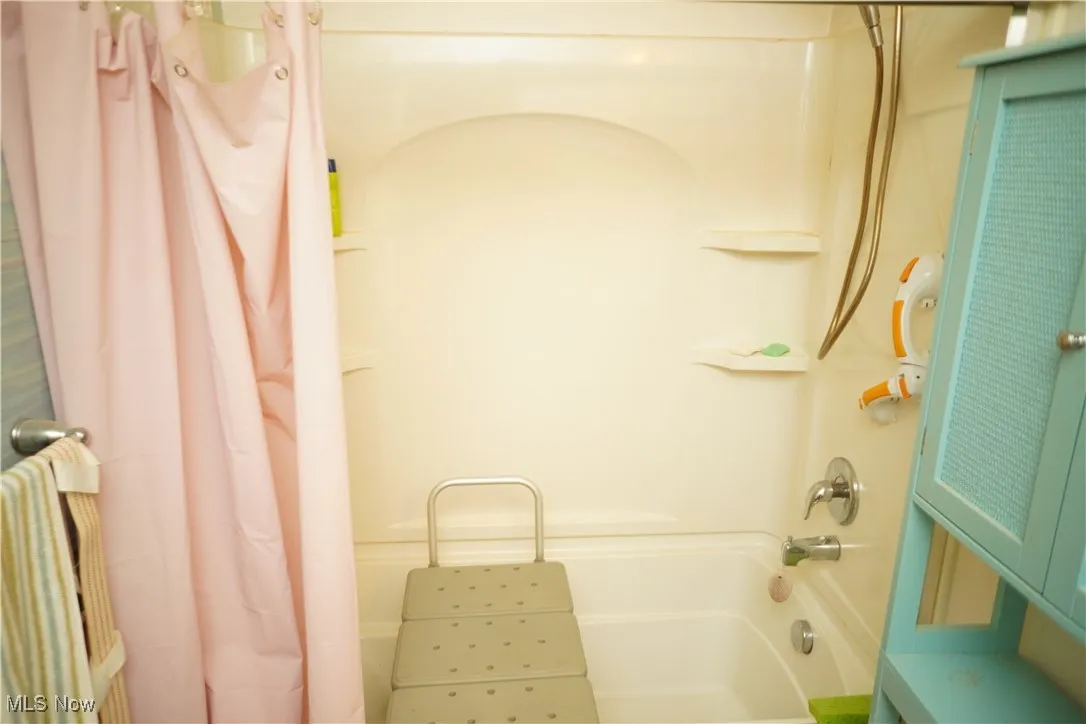 Bathroom featuring shower / bathtub combination with curtain