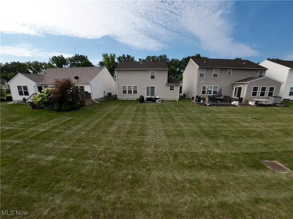 Back of house with a yard, a patio, and a residential view