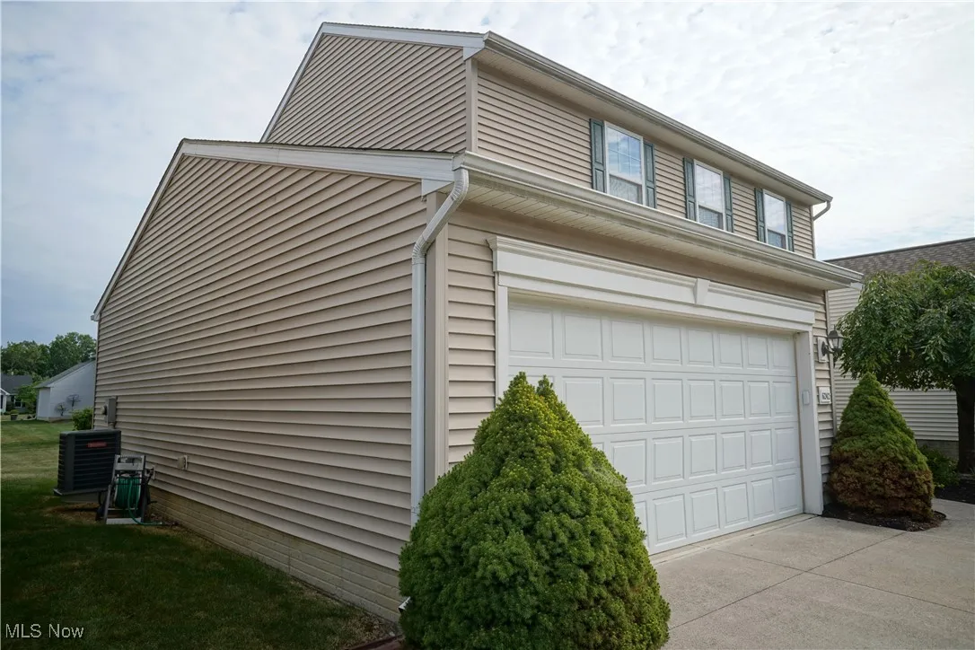 View of side of property with an attached garage and driveway