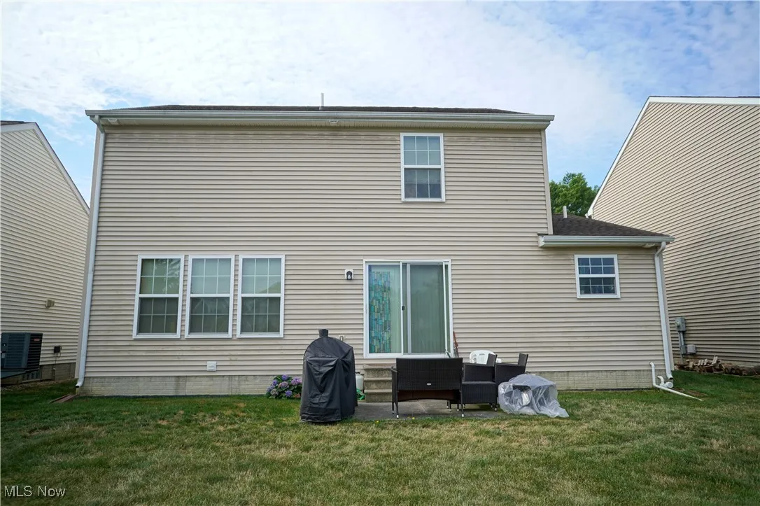Rear view of property featuring a patio area and a yard