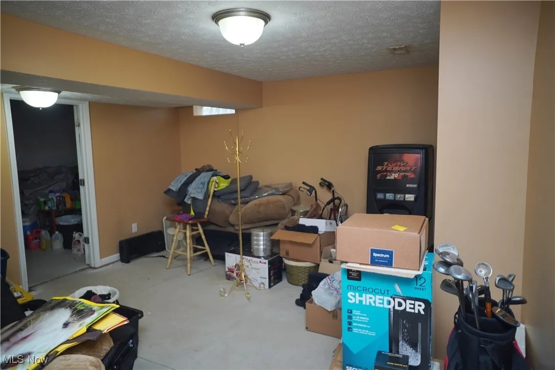 Below grade area with a textured ceiling and carpet flooring