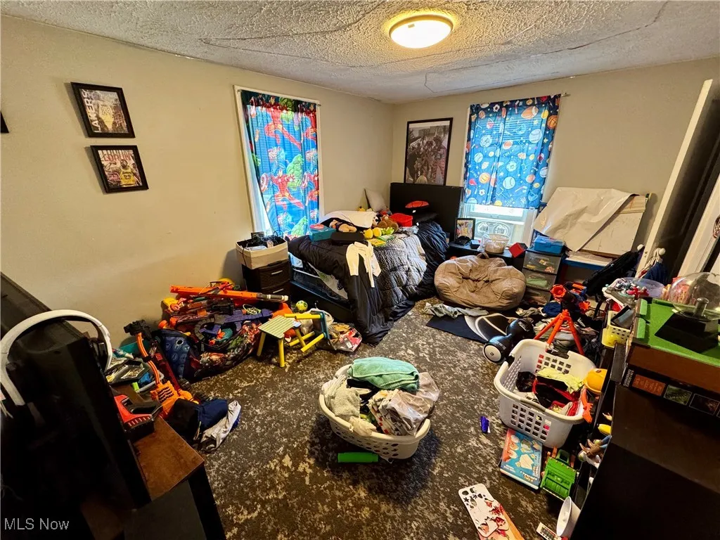 Bedroom featuring carpet flooring and a textured ceiling