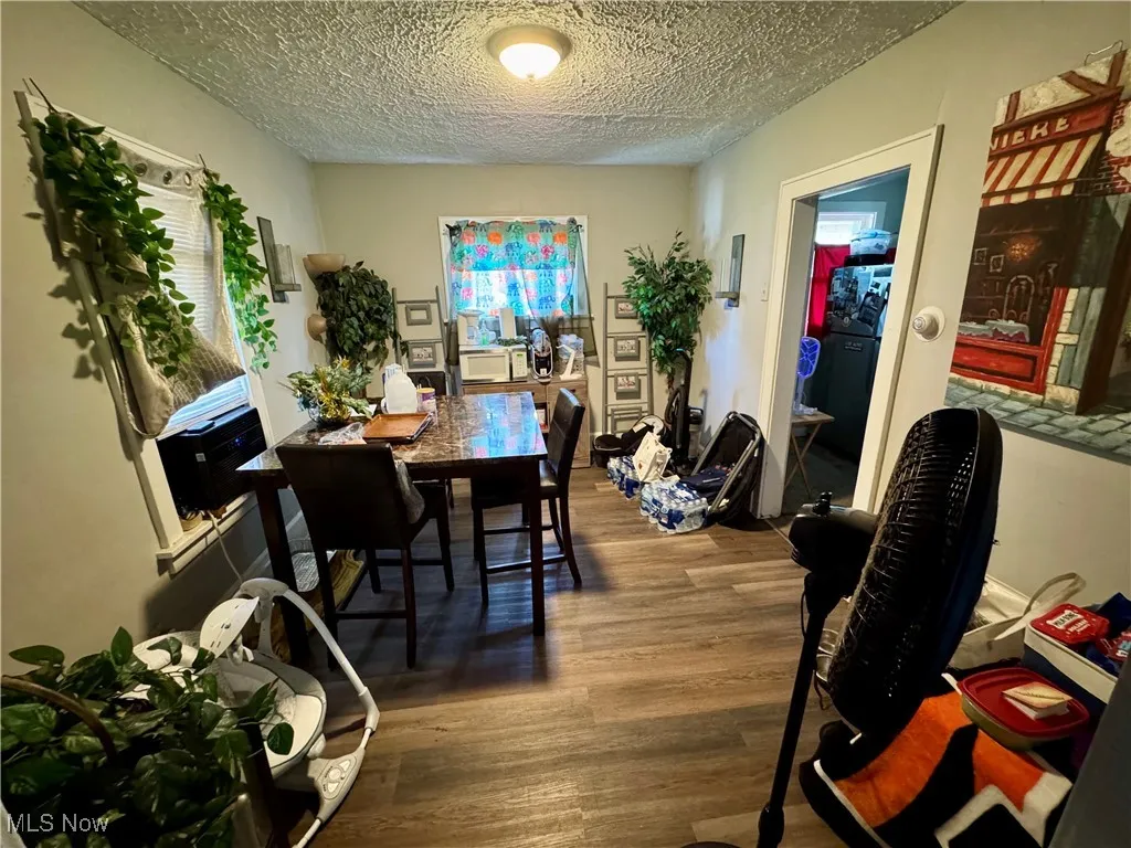 Dining space with wood finished floors and a textured ceiling