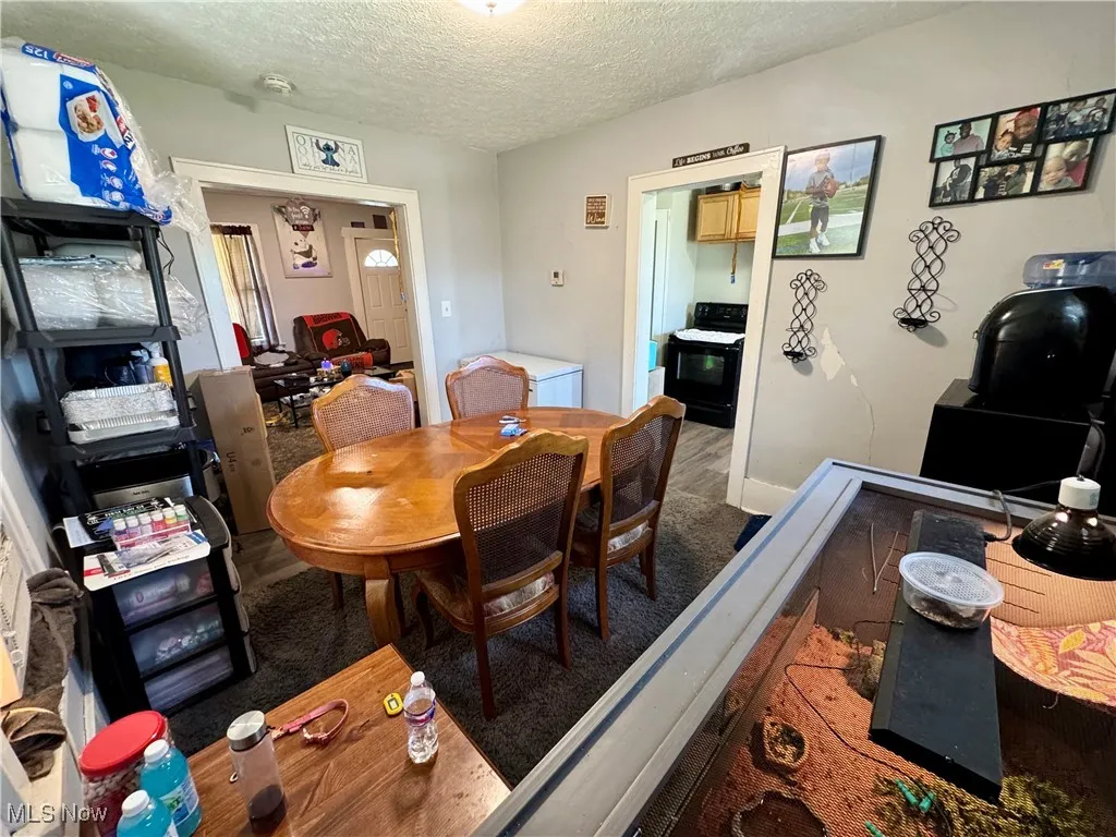 Dining space with a textured ceiling and wood finished floors