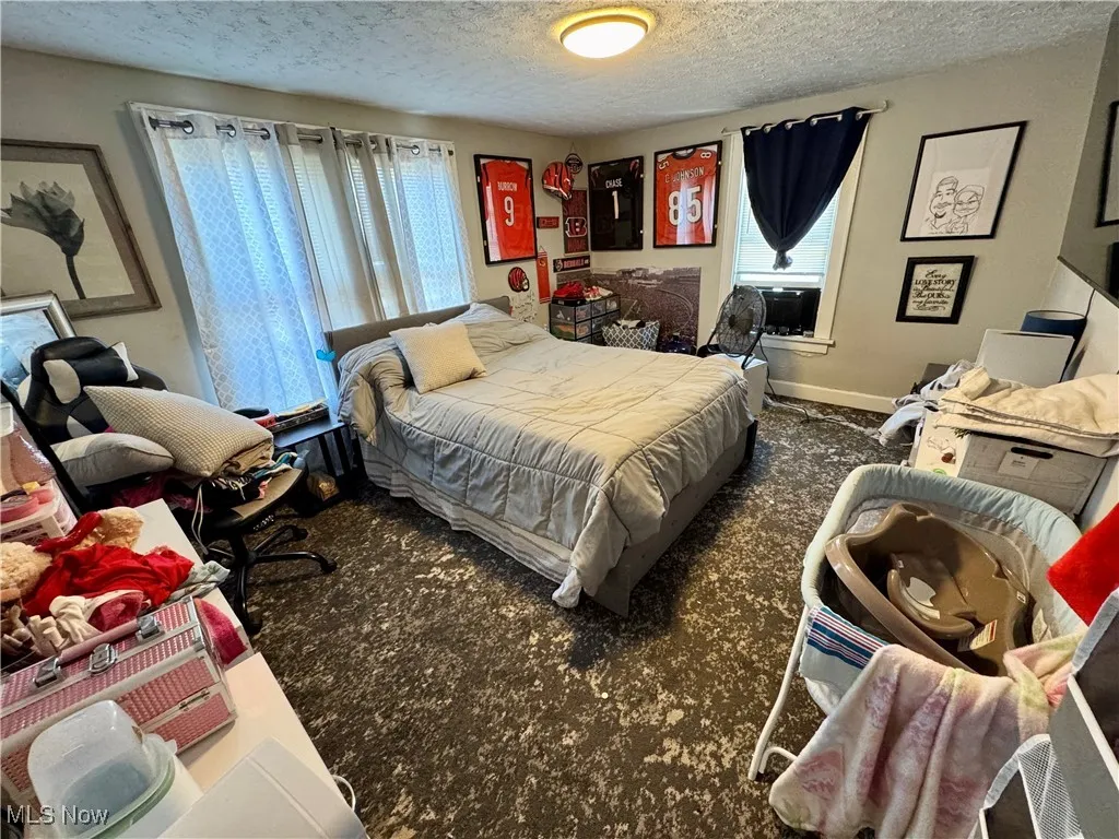 Bedroom featuring a textured ceiling and baseboards