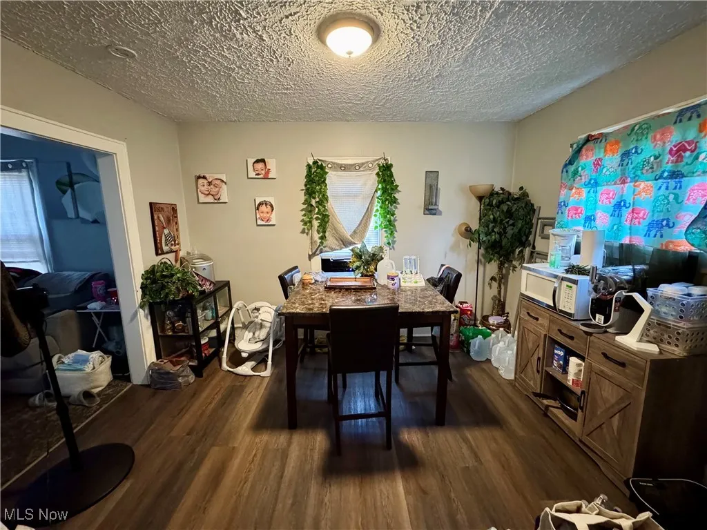 Dining room featuring dark wood-style flooring and a textured ceiling