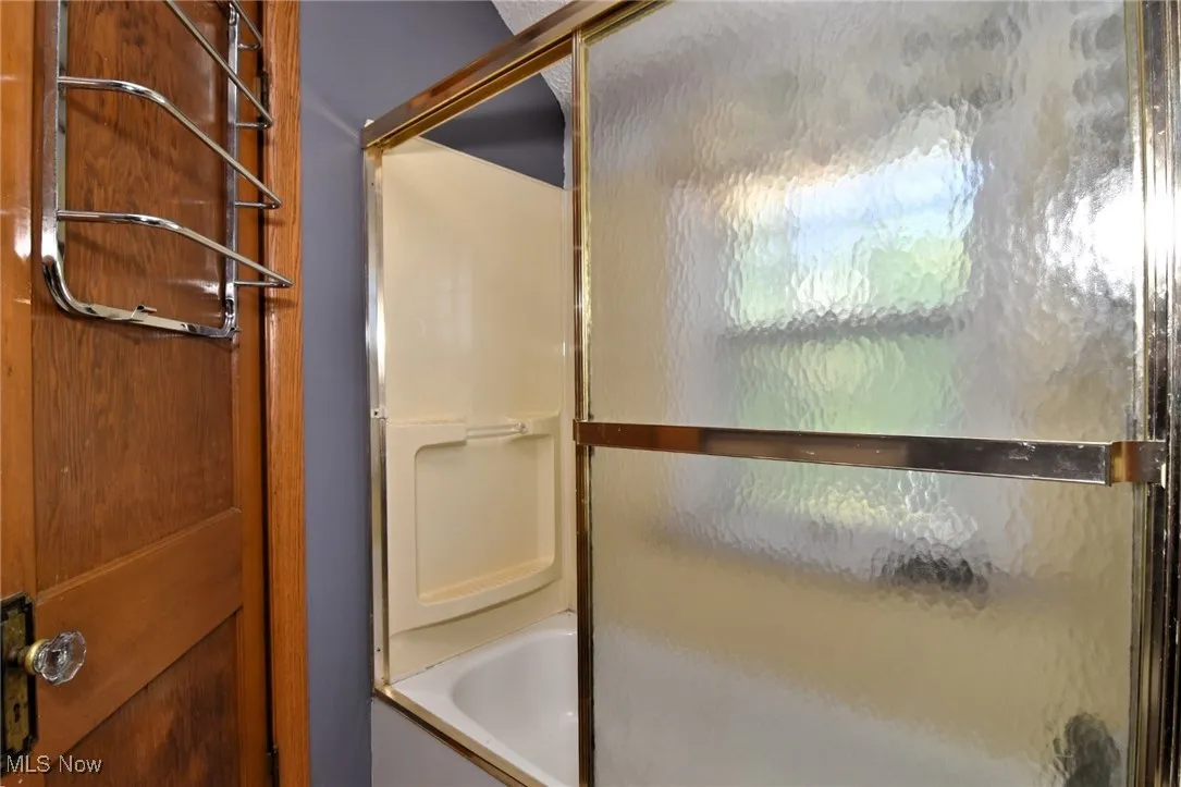 Full bath with combined bath / shower with glass door