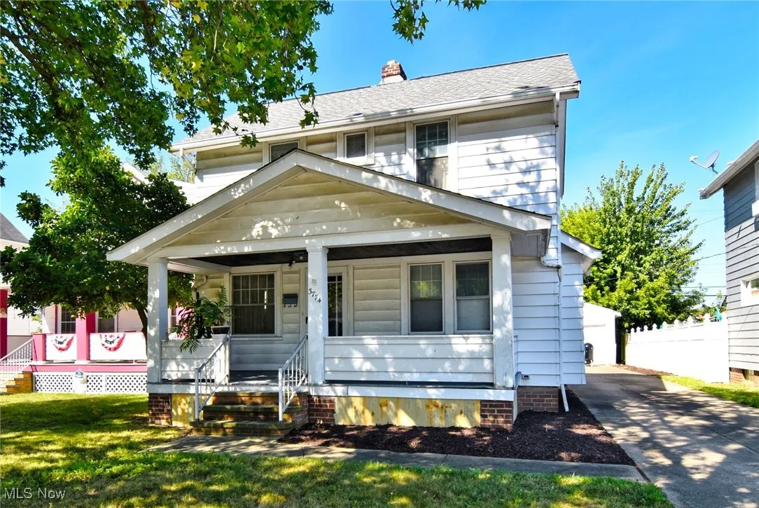 View of front of house featuring a porch, a chimney, and roof with shingles
