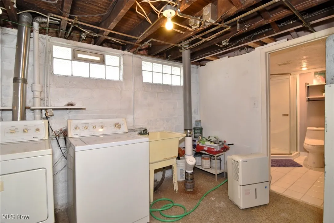 Laundry area featuring washing machine and dryer and tile patterned floors