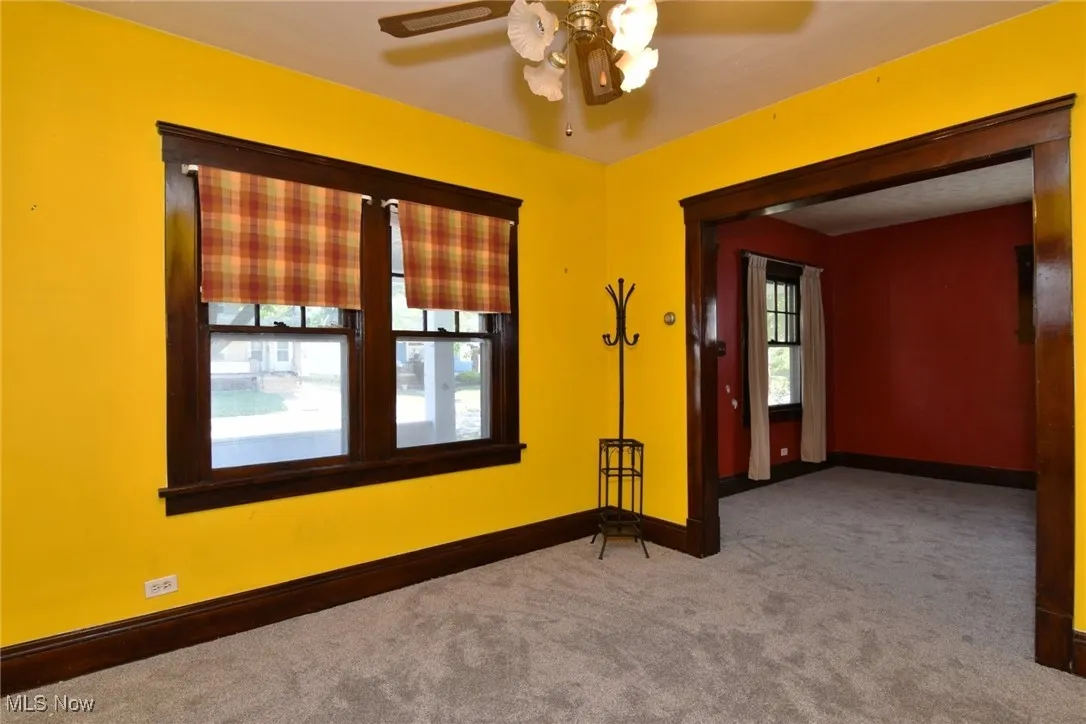 Carpeted empty room with baseboards and ceiling fan