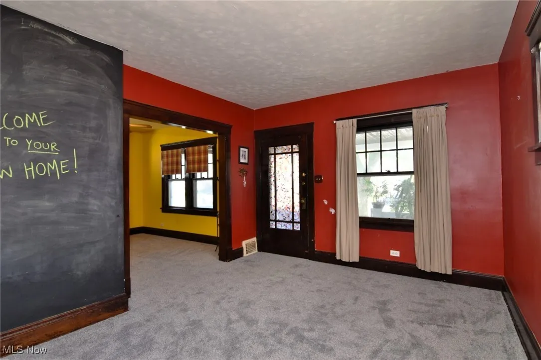 Foyer with carpet floors and a textured ceiling