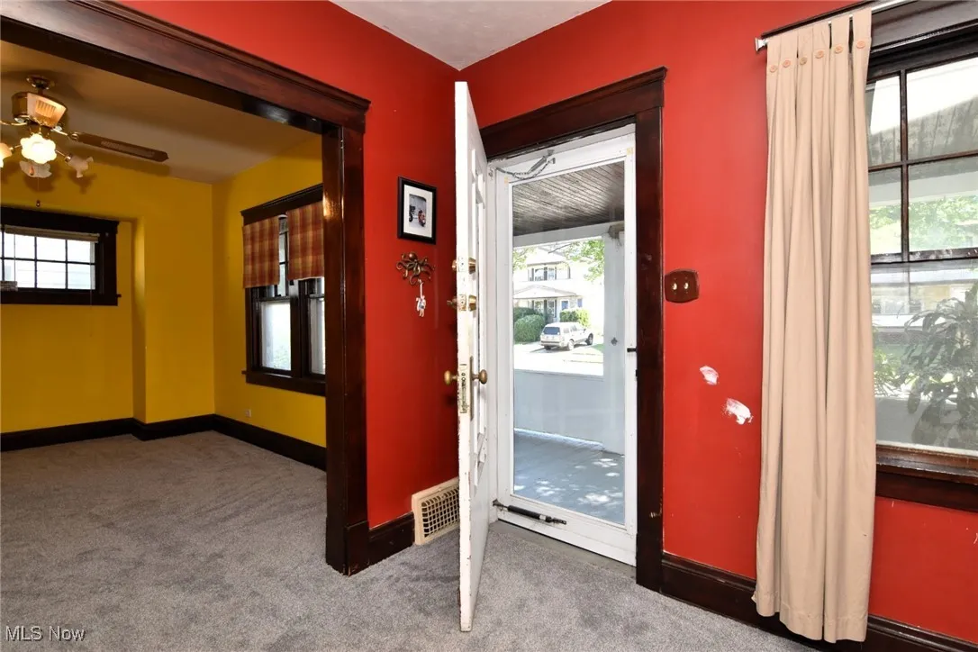 Doorway with carpet flooring and ceiling fan