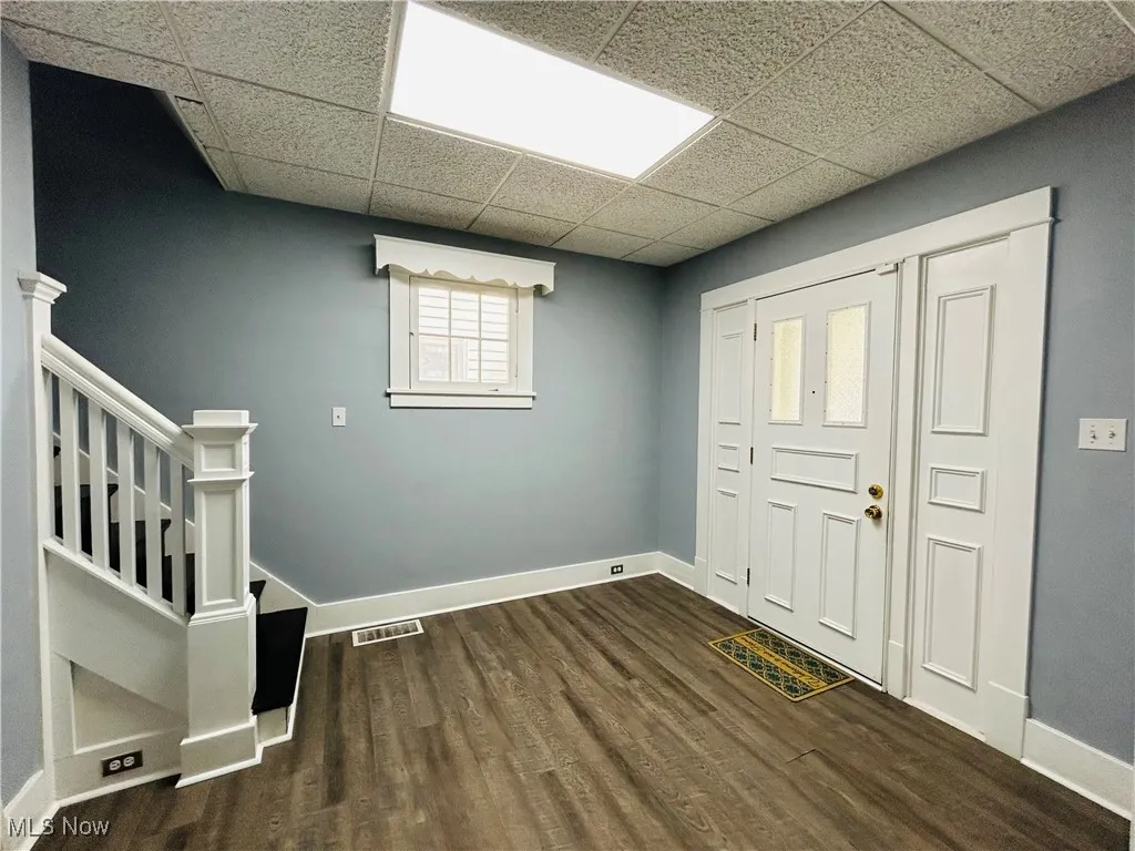 Foyer entrance featuring stairs and wood-style flooring