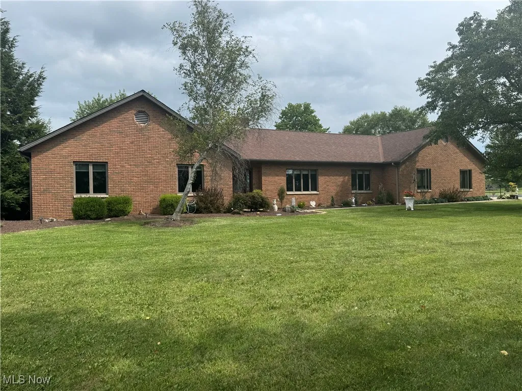 View of front facade with brick siding and a front lawn