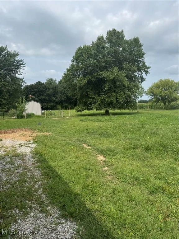 View of yard with an outdoor structure and a view of rural / pastoral area