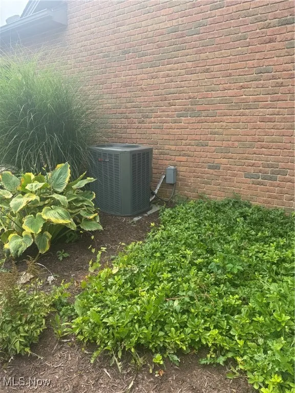 Exterior view of brick siding and a central air condition unit