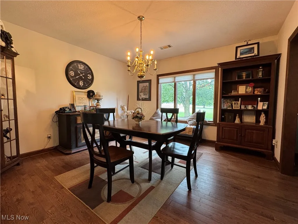 Dining area featuring dark wood finished floors and a chandelier