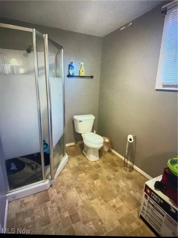 Bathroom featuring a stall shower and toilet